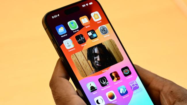 A customer holds an Apple iPhone 15 series device displayed for sale at The Grove Apple retail store on release day in Los Angeles, California, on September 22, 2023. (Photo by Patrick T. Fallon / AFP)