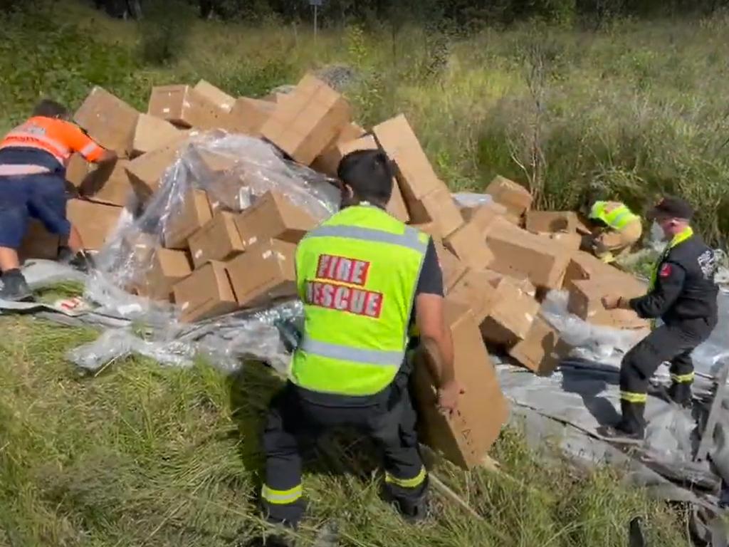 A large truck filled with rapid antigen tests rolled and spilt its cargo alongside the M7 Motorway in Sydney's West. Picture: Fire and Rescue NSW