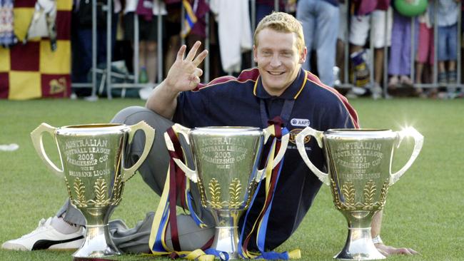 Voss with Brisbane’s three premiership cups from 2001-03.