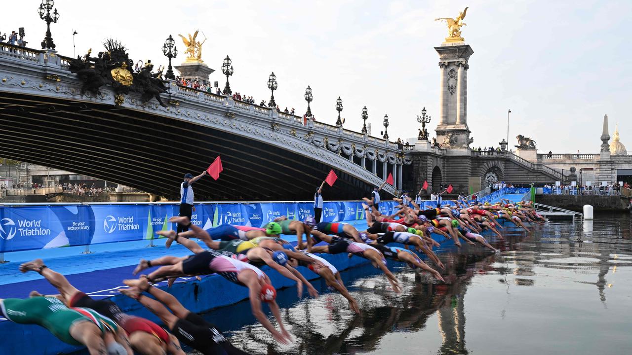 Triathlon athletes dive in the Seine river during the men's 2023 World Triathlon Olympic Games Test Event in Paris. (Photo by Bertrand GUAY / AFP)