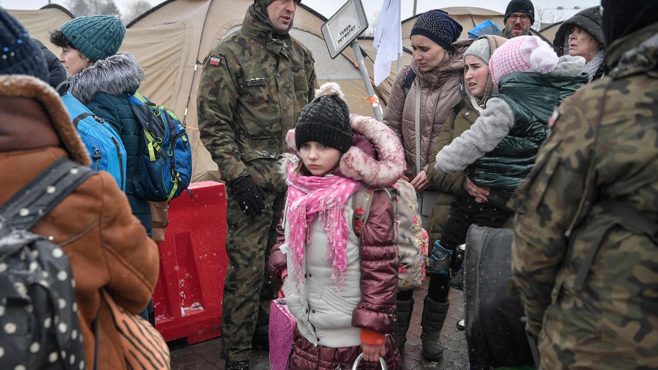 Newly arrived refugees seek assistance from Polish army soldiers after crossing the border from Ukraine into Poland. Picture: Louisa Gouliamaki/AFP