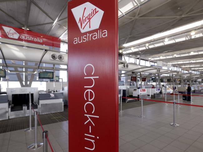 The Virgin Australia check-in counters are all but bare at Sydney Airport in Sydney, Wednesday, April 22, 2020. Virgin Australia is seeking bankruptcy protection, entering voluntary administration after a debt crisis worsened by the coronavirus shutdown pushed it into insolvency. (AP Photo/Rick Rycroft)