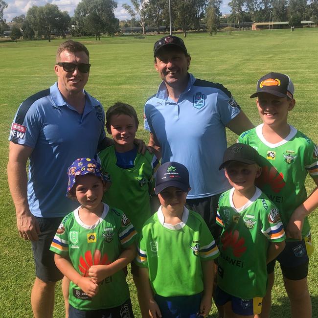 Laurie Daley and Trent Hodkinson with young footy players in Junee