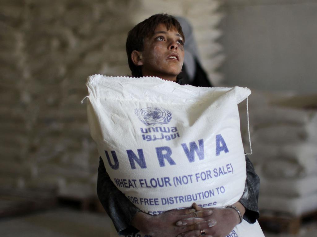 (FILES) A Palestinian boy holds a sack of flour at a United Nations Relief and Works Agency (UNRWA) aid distribution centre in Gaza City on April 10, 2013. The United Nations reopened aid distribution centres in Gaza, after a four-day closure in response to the storming of its offices last week by protesters demanding reinstatement of a monthly cash allowance to poor families which was halted from April 1 due to budget cuts. AFP PHOTO/MAHMUD HAMS. Israel's parliament on October 29, 2024, banned the United Nations agency for Palestinian refugees (UNRWA) from operating in Israel and occupied east Jerusalem, despite objections from the international community. UNRWA chief Philippe Lazzarini condemned the decision, saying it set "a dangerous precedent". (Photo by Mahmud HAMS / AFP)