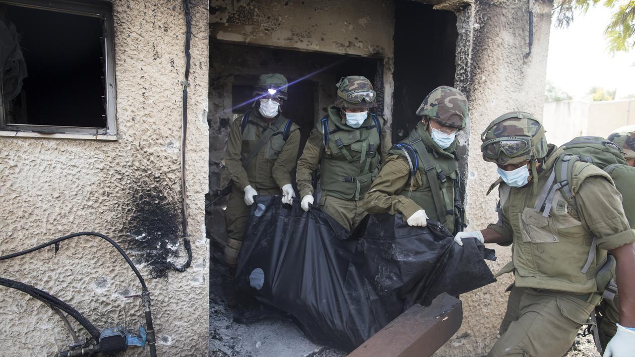 Israeli soldiers remove the body of civilian who was killed on this kibbutz near the border with Gaza. Picture: Getty Images