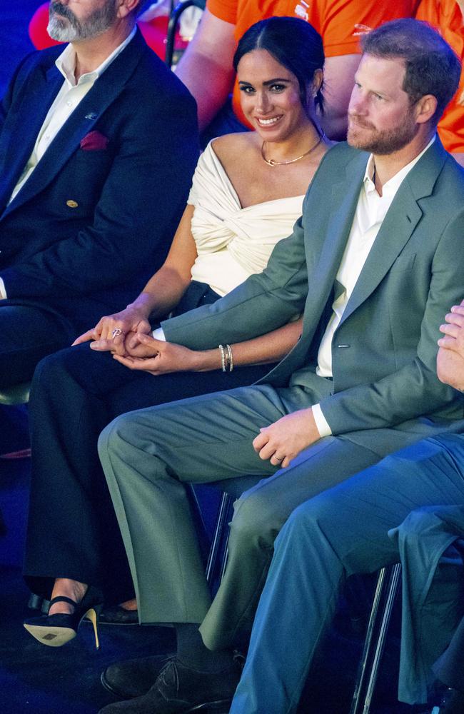 Megan holds Prince Harry’s hand during the opening ceremony. Picture: Koen van Weel / ANP / AFP