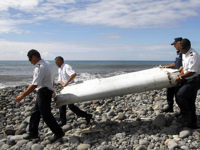 A file photo dated 29 July 2015 showing officers carrying a flaperon from an aircraft apparently washed ashore in Saint-Andre de la Reunion, eastern La Reunion island, France. Picture: EPA