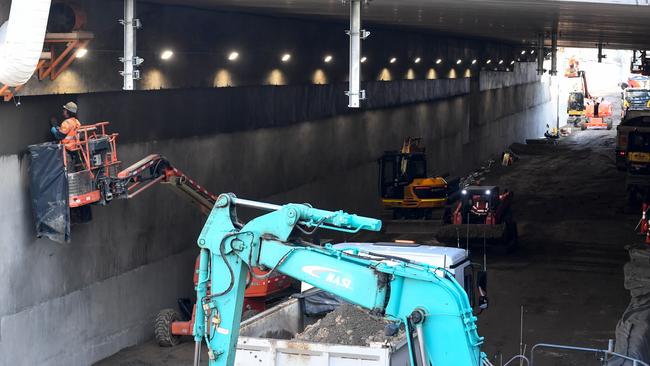 Tradies work inside the Cheltenham trench. Picture: Penny Stephens