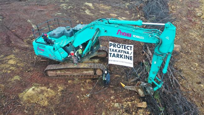 Protester and signage with mining equipment at the Riley Mine. PICTURE: Bob Brown Foundation