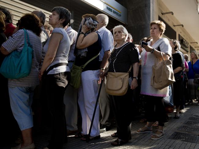 Pensioners line up as the wait to be allowed into a bank in Athens ... They can withdraw a maximum of 120 euros for the week. Picture: AP/Petros Giannakouris