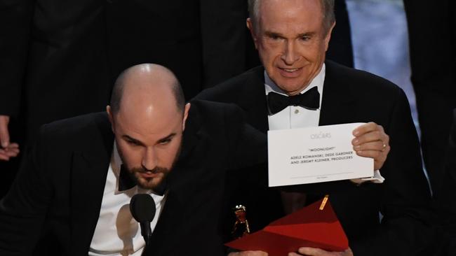 US actor Warren Beatty (C) shows the card reading Best Film 'Moonlight