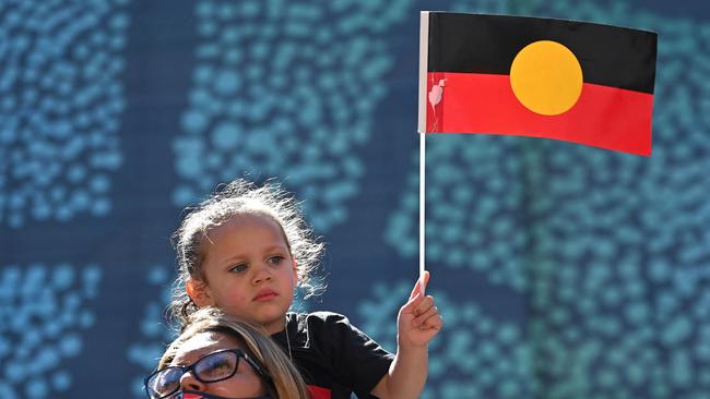 A young girl holds up an Australian Aboriginal flag during an ‘Invasion Day’ demonstration in Sydney on January 26, 2022. Picture: Steven Saphore / AFP