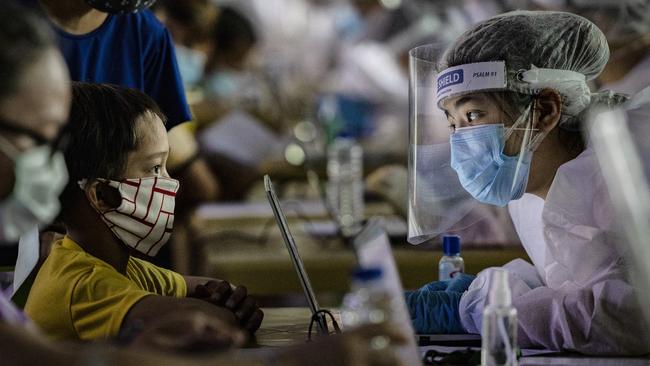 A medic interviews a child for a free COVID-19 test in Manila on Thursday. Picture: Getty Images