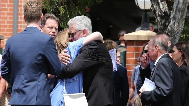 Lilie's father James and brother Max watch on as her mother Peta hugs a mourner. Picture: Britta Campion