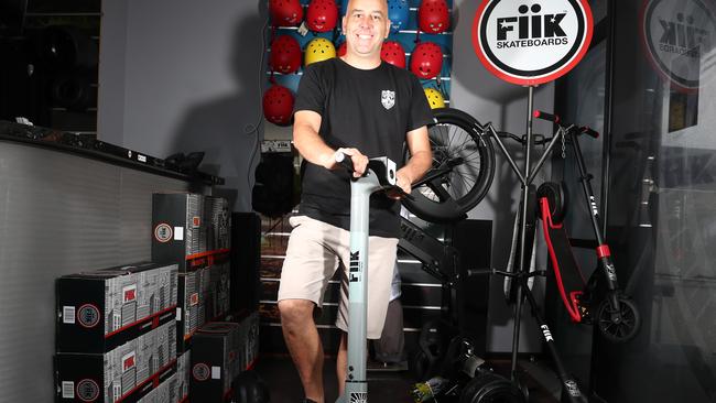 Fiik Skateboards general manager Grant Stedman posing with one of their e-scooters at their Ormeau base. Photograph: Jason O'Brien