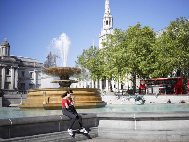 A lone woman sits in an empty Trafalgar Square in London. Picture: AFP