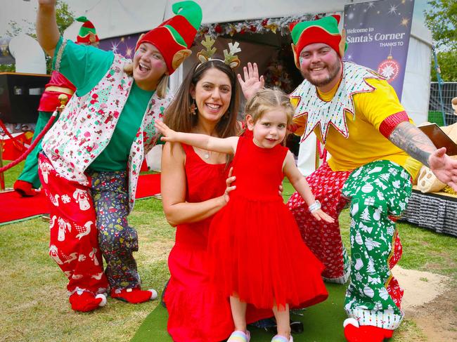 ADELAIDE, SOUTH AUSTRALIA - Advertiser Photos DECEMBER 14, 2024: Angela Versace with Daughter Ariana 3yrs with Santas Elves Hilary and Fynn at Carols by Candlelight 2024 at Elder Park Picture: Emma Brasier