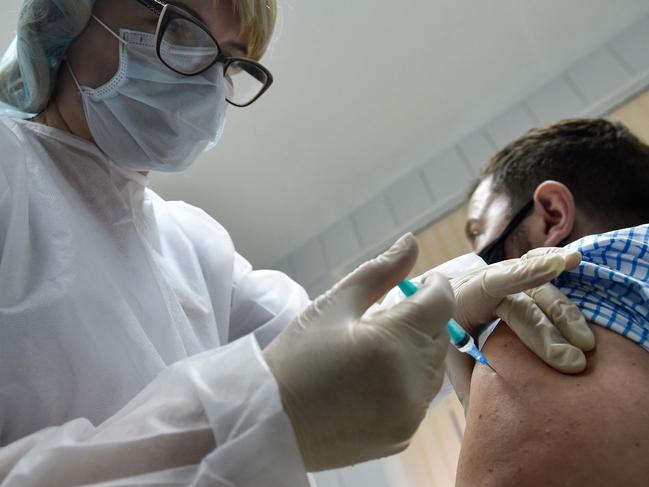 A nurse inoculates volunteer Ilya Dubrovin, 36, with Russia's new coronavirus vaccine in a post-registration trials at a clinic in Moscow on September 10, 2020. - Russia announced last month that its vaccine, named "Sputnik V" after the Soviet-era satellite that was the first launched into space in 1957, had already received approval. The vaccine was developed by the Gamaleya research institute in Moscow in coordination with the Russian defence ministry. (Photo by Natalia KOLESNIKOVA / AFP)