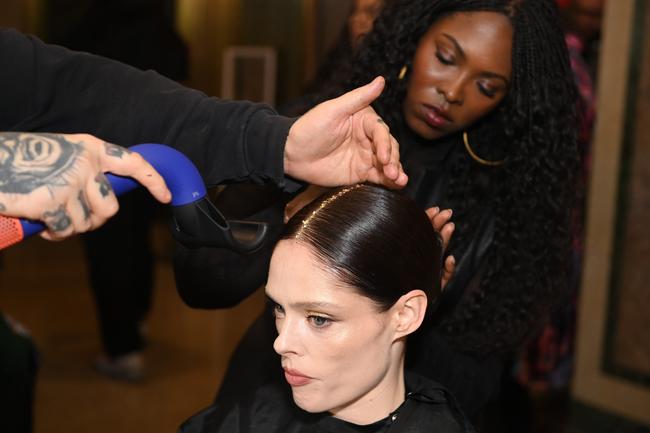 NEW YORK, NEW YORK - FEBRUARY 08: Head stylist Lacy Redway prepares Coco Rocha backstage for TRESemme X Christian Siriano at The Plaza on February 08, 2024 in New York City. (Photo by Dave Kotinsky/Getty Images for TRESemme)