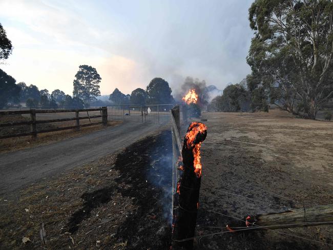 A burning fencepost is pictured on a residential property as bushfires hit the area around the town of Nowra in the Australian state of New South Wales on December 31, 2019. - Thousands of holidaymakers and locals were forced to flee to beaches in fire-ravaged southeast Australia on December 31, as blazes ripped through popular tourist areas leaving no escape by land. Picture: Saeed Khan/AFP