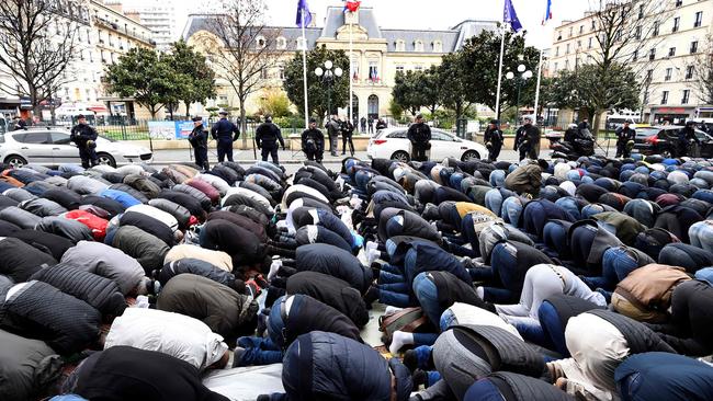 French police watch Muslims praying in the street during a protest in March. Picture: AFP