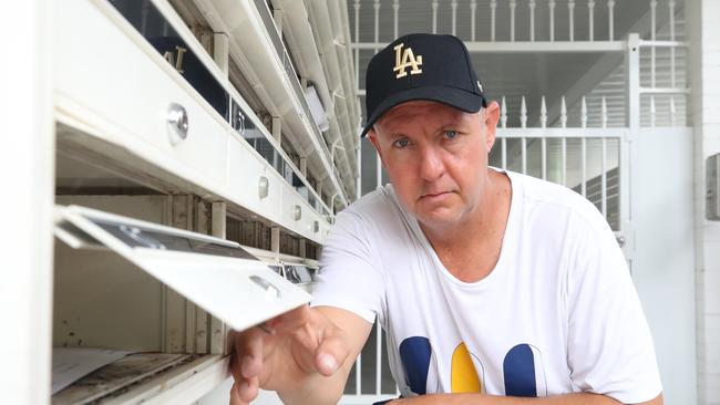 Panorama Tower body corporate committee member Cameron Moir said a mail thief broke into every letterbox – and Mr Moir demonstrates. Picture: Glenn Hampson