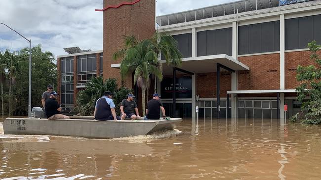 Police ride past a flooded city hall on Tuesday, a day after Lismore was hit by a record flood. Picture: Stuart Cumming