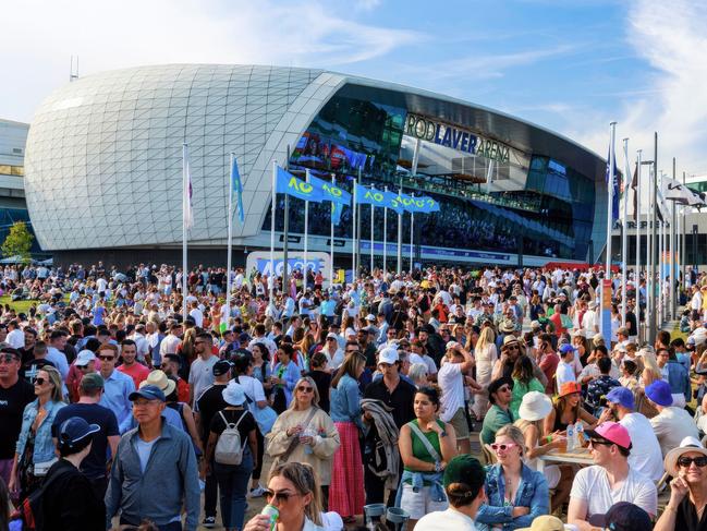 Crowds at Grand Slam Oval with signage during the Australian Open. Picture: Aaron Francis