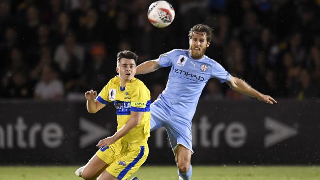 BRISBANE, AUSTRALIA — OCTOBER 01: Jake McLean of the Strikers and Joshua Brillante of Melbourne City compete for the ball during the FFA Cup 2019 Semi Final between the Brisbane Strikers and Melbourne City FC at Perry Park on October 01, 2019 in Brisbane, Australia. (Photo by Albert Perez/Getty Images)