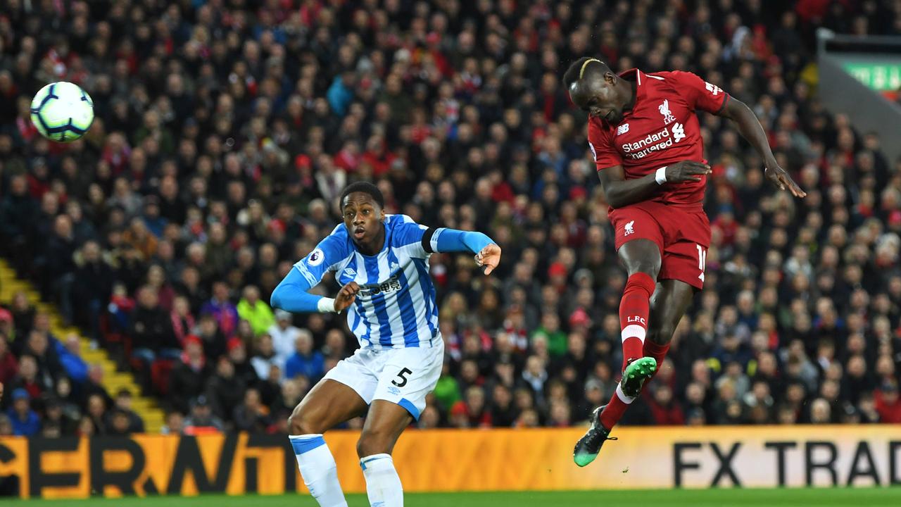 Sadio Mane of Liverpool scores his team's second goal as Terence Kongolo of Huddersfield Town looks on