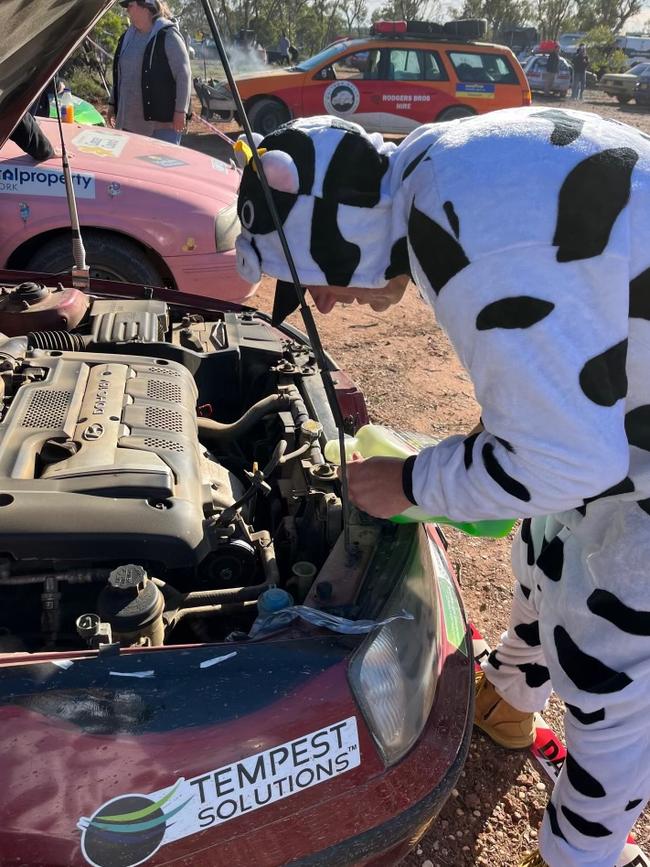Mal checking out the engine of their car on a previous rally. Supplied.