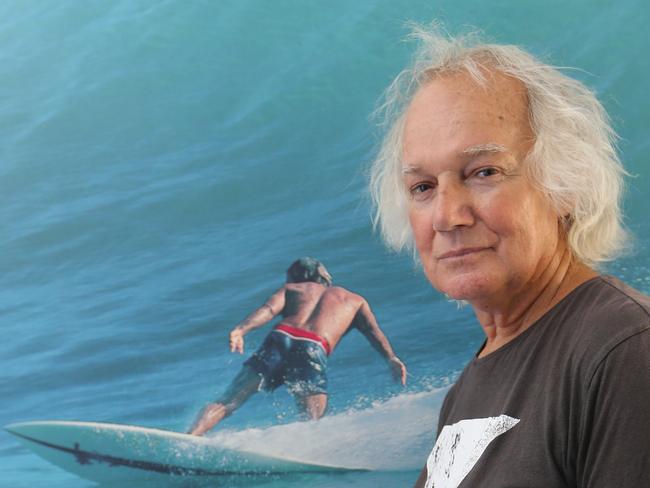 Peter Drouyn ,the inventor of the man-on-man surf format with the 1970s Burleigh Stubbies events and the surfer of note,  has smashed Sea Shepherd for comments on Gold coast shark nets. Peter at home in front of a portrait of him surfing at Burleigh. Picture Glenn Hampson