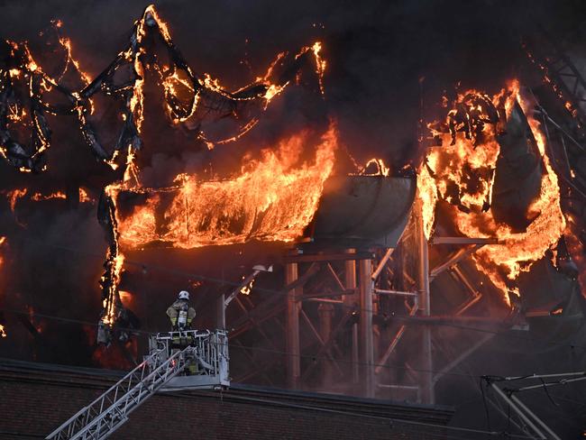 A firefighter is seen on an aerial ladder platform as a fire engulfs a structure of the Oceana Waterworld at the Liseberg Amusement Park in Gothenburg, Sweden on February 12, 2024. (Photo by Bjorn LARSSON ROSVALL / TT News Agency / AFP) / Sweden OUT