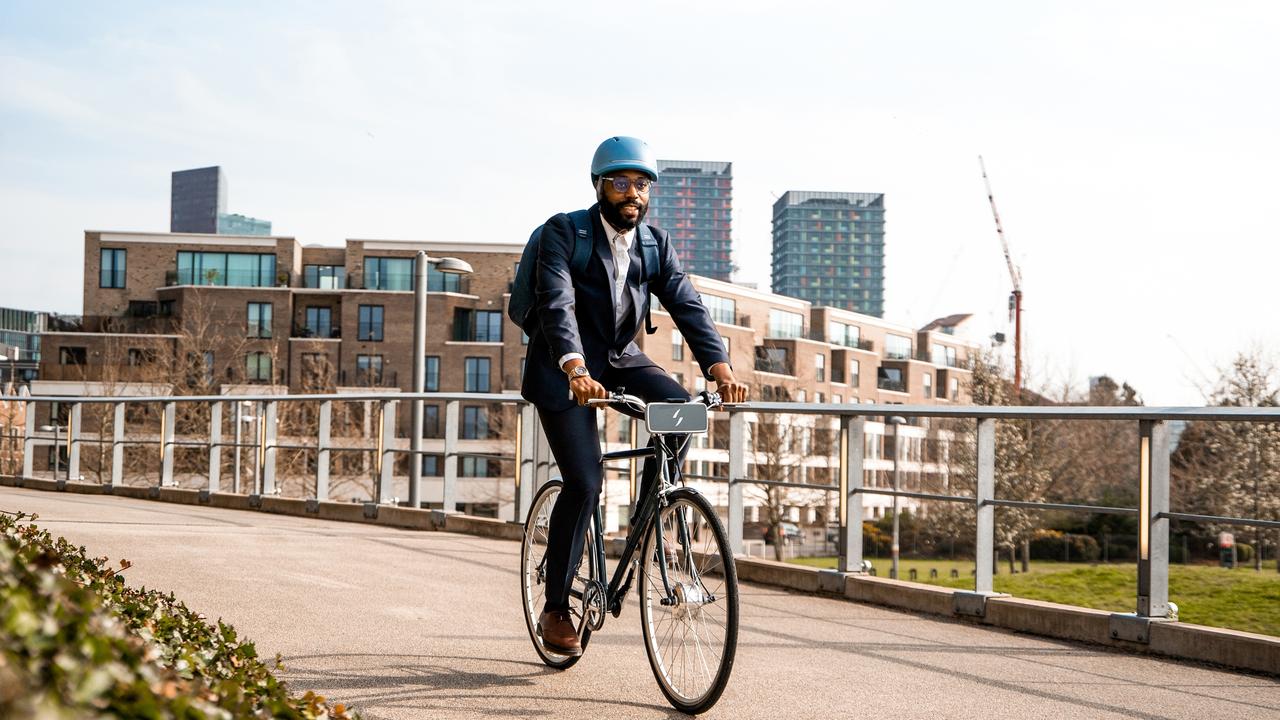 A man riding a bicycle with the Swytch kit installed.