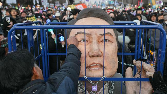 A protester calling for the ouster of South Korea President Yoon Suk Yeol punches an effigy of him after the result of the second martial law impeachment vote outside the National Assembly in Seoul. Picture: AFP