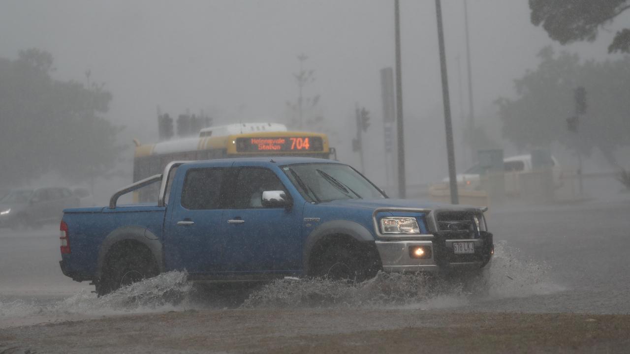 A car drives through water on Queen St in Southport after a storm lashes the Gold Coast. Photograph : Jason O’Brien