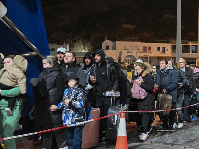 People embark a ferry as they leave in the wake of recurring earthquakes, on the Greek Island of Santorini, on February 4, 2025. Fresh overnight tremors shook Greece's top tourist island Santorini, media reports said, prompting people to sleep outdoors and others to leave by plane or ferry. (Photo by -STR / AFP)