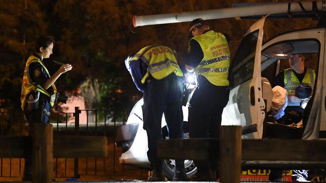 Police investigate the crash scene after two officer were taken to hospital with serious leg injuries. Picture: Gordon McComiskie