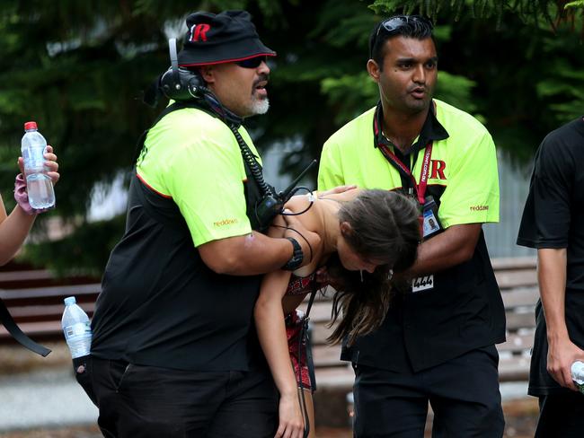 A girl is carried by security to paramedics outside the Rolling Loud Festival on Sunday. Picture: Damian Shaw