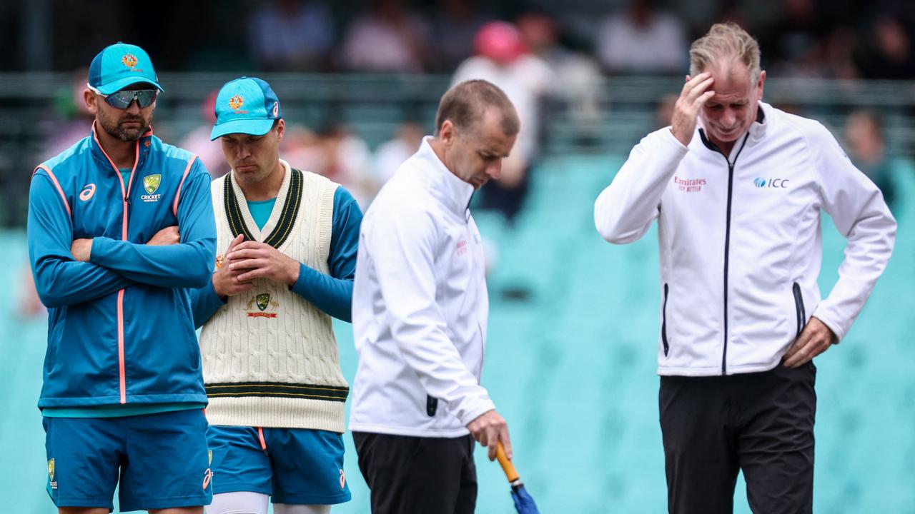 Australian players Nathan Lyon (L) and Alex Carey (2nd L) inspect the pitch with umpires Paul Reiffel (R) and Chris Gaffaney. (Photo by DAVID GRAY / AFP)
