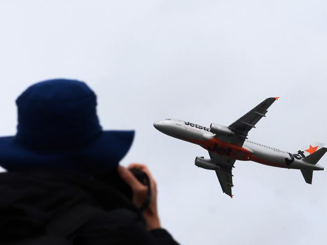 SYDNEY, AUSTRALIA - JANUARY 20: A woman photographs from ShepÃ¢â¬â¢s Mound, a plane spottersÃ¢â¬â¢ lookout as a Jetstar plane takes off from Sydney International airport January 20, 2024 in Sydney, Australia. Transport Minister Catherine King signed off on a deal that will allow Turkish Airlines to start serving the Australian market, rising to 35 flights a week by 2025. The decision came as the government was under mounting criticism from many for a perception that it was protecting the profits of Qantas and stymying competition in the market by limiting additional capacity for other carriers, such as Qatar Airways. (Photo by Jenny Evans/Getty Images)