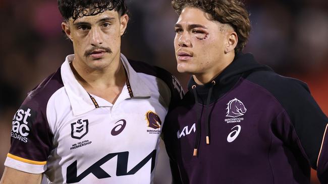 Kotoni Staggs with injured Reece Walsh. Picture: Jason McCawley/Getty Images