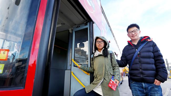 Chinese tourists Yanzhu Chen, left, and Nan Hu jump aboard the hop-on, hop-off Red Decker tour bus around Hobart. Picture: PATRICK GEE