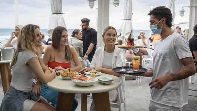 Sisters Te’a, 20, Stella, 20, and Sian O’Leary, 23, enjoy cocktails served by Lachlan Jones at Burleigh Pavilion on the Gold Coast. Picture: Russell Shakespeare