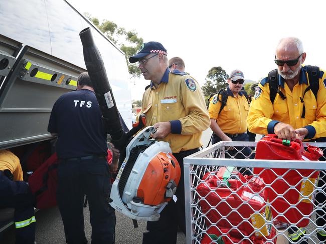 Firefighters from the TFS and NSW Rural Fire Service load equipment onto buses ahead of the weekend firefighting efforts. Picture: NIKKI DAVIS-JONES