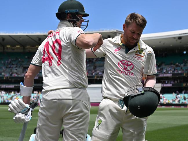 Australiaâs Steve Smith (L) hugs teammate David Warner who walks out after dismissal for the last time in his 112th and farewell Test on day four of the third cricket Test match between Australia and Pakistan at the Sydney Cricket Ground in Sydney on January 6, 2024. (Photo by Saeed KHAN / AFP) / -- IMAGE RESTRICTED TO EDITORIAL USE - STRICTLY NO COMMERCIAL USE --