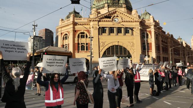 Animal-rights protesters block the intersections of Flinders and Swanston sts during early-morning traffic in Melbourne. Picture: AAP