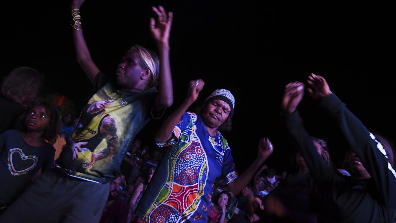 Locals dance during a concert at the official ceremony to celebrate the closure of the climb at Uluru-Kata Tjuta National Park in the Northern Territory. Picture: AAP Image/Lukas Coch.