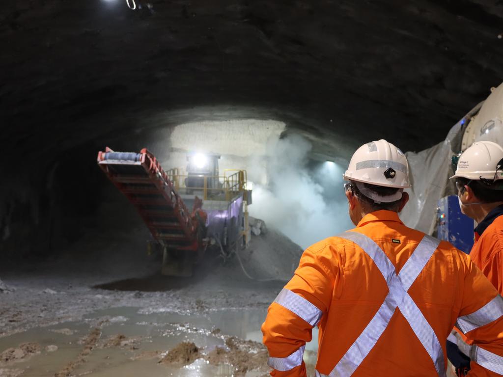 Construction staff keep an eye on a roadheader tunnelling at Arncliffe as it churns its way through rock in a bid to save time for Sydney motorists.