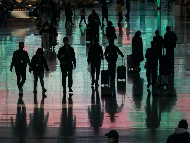 HONG KONG, CHINA - DECEMBER 30: Travellers walk with their luggage at the arrival hall of the Hong Kong International Airport on December 30, 2022 in Hong Kong, China. Authorities around the world are imposing or considering curbs on travellers from China as COVID-19 case there surge following its relaxation of Zero-COVID rules. (Photo by Anthony Kwan/Getty Images)